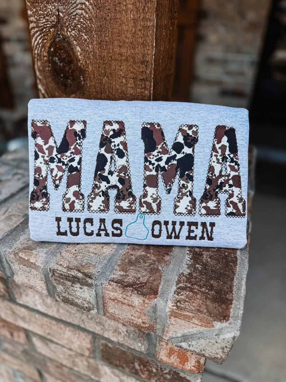 Cow print MAMA appliqué with Lucas and Owen names and cattle tag, front view